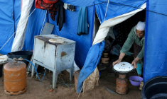 Une femme prépare à manger dans l'une des tentes d'un camp destiné aux personnes touchées par les inondations qui ont frappé le nord et l'ouest du Maroc, dans la région de Kénitra, le 20 février 2026 ( AFP / Abdel Majid BZIOUAT )