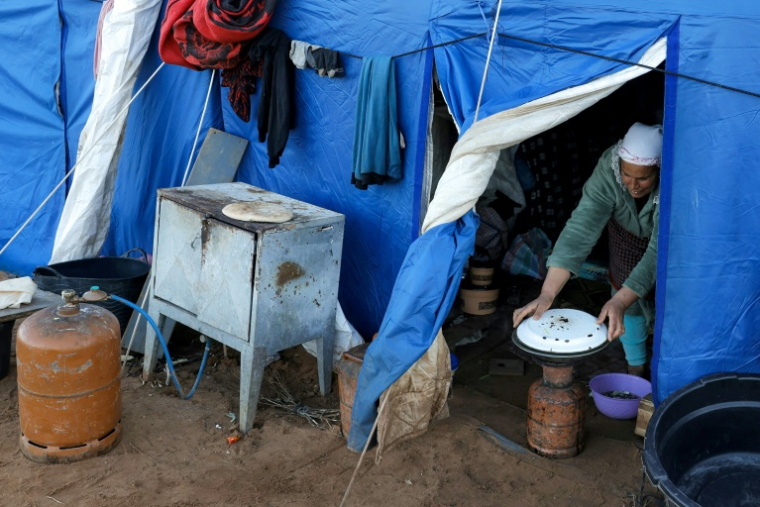 Une femme prépare à manger dans l'une des tentes d'un camp destiné aux personnes touchées par les inondations qui ont frappé le nord et l'ouest du Maroc, dans la région de Kénitra, le 20 février 2026 ( AFP / Abdel Majid BZIOUAT )