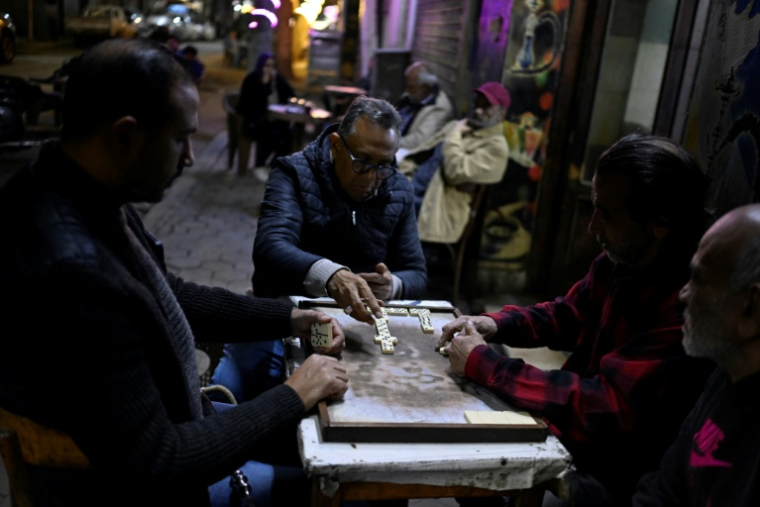 Des personnes jouent à un jeu de dominos dans un café, dans le centre-ville du Caire, le 2 avril 2026 ( AFP / Khaled DESOUKI )