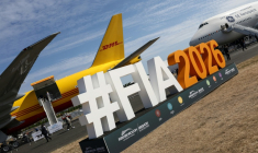 Le logo du salon aéronautique international de Farnborough devant un Boeing 777-200 (g) du géant du transport DHL et un Boeing 747 de GE Aerospace (d), lors de la journée d'ouverture à Farnborough, au sud-ouest de Londres, le 20 juillet 2026 ( AFP / Toby Shepheard )