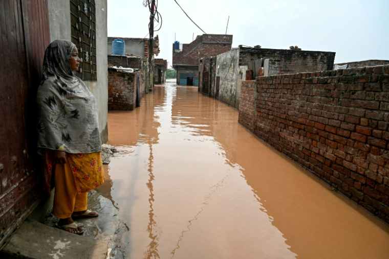 Ghulam Bano près de sa maison submergée par les eaux en crue du fleuve Ravi à Shahdara, le 29 août 2025 au Pakistan ( AFP / Aamir QURESHI )