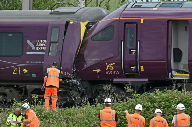 Des agents de la police des transports britannique et des enquêteurs sur le site d'une collision entre deux trains de la compagnie East Midlands Railway (EMR) survenue la veille, le 20 juin 2026 au sud de Bedford, dans le centre de l'Angleterre  ( AFP / JUSTIN TALLIS )