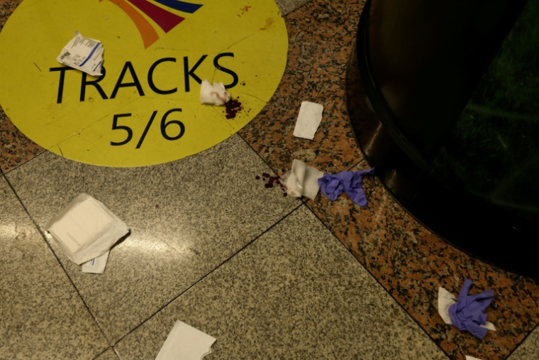 Des compresses, des gants médicaux et du sang au sol de la gare Penn Station à New York, où cinq personnes ont été blessées à coups de couteau par une personne qui a été appréhéndée, le 7 juin 2026 ( AFP / John Lamparski )