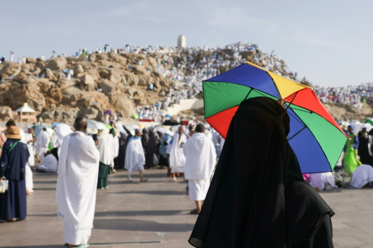 Un pèlerin se protège du soleil avec un parapluie, au pied du mont Arafat le 5 juin 2025 ( AFP / HAZEM BADER )