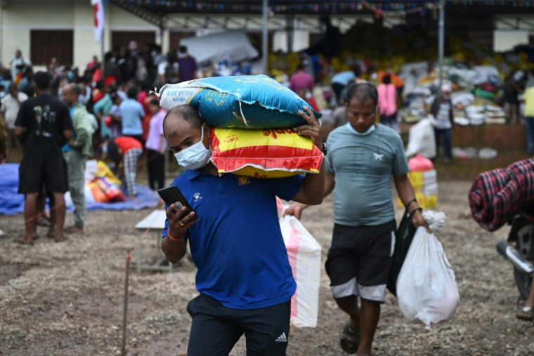 Des rescapés du "tsunami himalayen" quittent un camp de secours temporaire après avoir reçu une aide matérielle à Devighat, dans le district de Nuwakot au Népal, le 3 septembre 2026 ( AFP / Arun SANKAR )