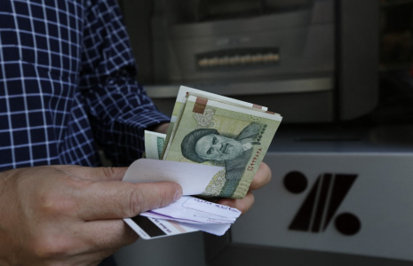 Un homme tenant des rials à Téhéran, en Iran. ( AFP / ATTA KENARE )