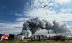 Un hélicoptère bombardier d'eau s'apprête à faire un largage au-dessus d'un incendie dans un centre logistique du géant russe de l'e-commerce Wildberries, le 16 août 2026 à Podolsk, près de Moscou ( AFP / TATYANA MAKEYEVA )