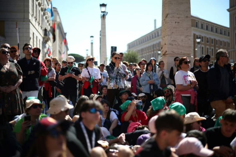 Des personnes suivent les funérailles du pape François sur un écran installé Via della Conciliazione, près du Vatican, le 26 avril 2025 à Rome ( AFP / HENRY NICHOLLS )