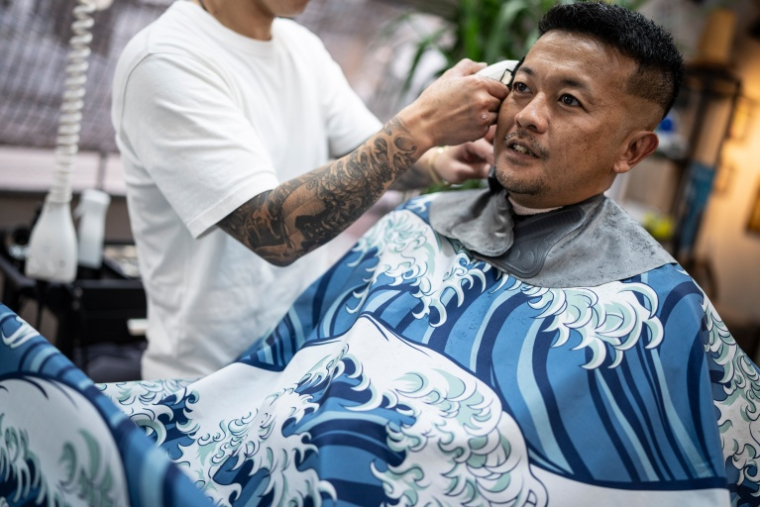 Le yakuza et ancien rappeur Tekisasu, 44 ans, dans un barbershop de Tokyo au Japon, le 27 août 2026 ( AFP / Yuichi YAMAZAKI )