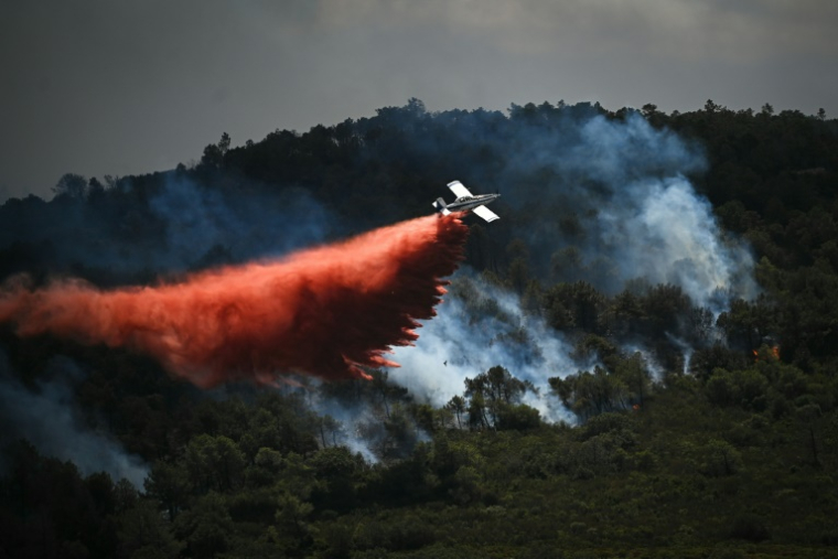 Un avion de lutte contre les incendies largue un produit retardant sur un incendie de forêt, près de Narbonne, le 8 juillet 2025 dans l'Aude ( AFP / Matthieu RONDEL )