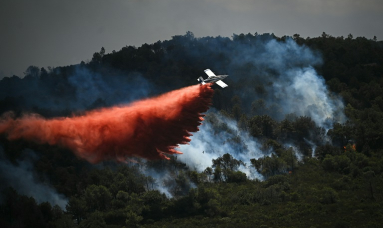 Un avion de lutte contre les incendies largue un produit retardant sur un incendie de forêt, près de Narbonne, le 8 juillet 2025 dans l'Aude ( AFP / Matthieu RONDEL )