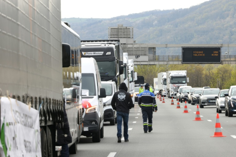 Un policier sur le site d'une manifestation de chauffeurs routiers bloquant l'autoroute A7, au sud de Lyon, pour protester contre la hausse des prix du carburant, à Chasse-sur-Rhône, le 28 mars 2026 en Isère ( AFP / Alex MARTIN )