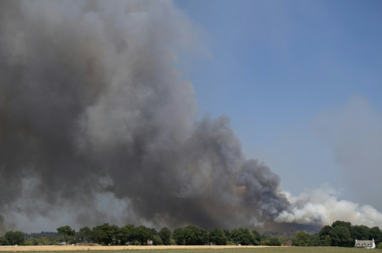 De la fumée s'élève dans le ciel lors d'un feu de forêt à Campénéac, dans le Morbihan, e 12 août 2022 ( AFP / FRED TANNEAU )