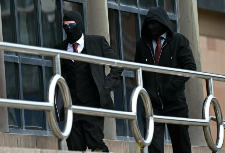 Daniel Graham (G) et Adam Carruthers (D), le visage couvert, arrivent au tribunal de Newcastle le 15 mai 2024, accusés d'avoir abattu le célèbre Sycamore Gap tree en septembre 2023 ( AFP / Paul ELLIS )