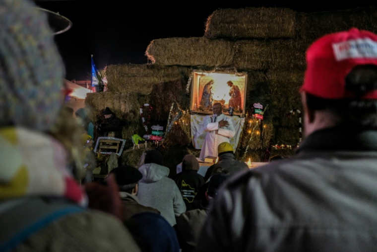Des participants au blocage de l'autoroute A63 à Cestas, au sud de Bordeaux, assistent à une messe le 24 décembre 2025 ( AFP / Thomas BERNARDI )