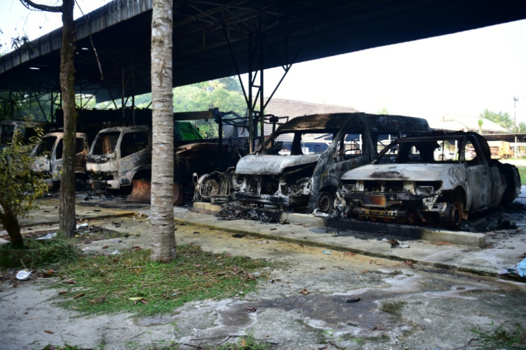 Des véhicules calcinés après une série d'attaques  incendiaires dans la province méridionale thaïlandaise de Narathiwat, le 23 août 2026  ( AFP / Madaree TOHLALA )