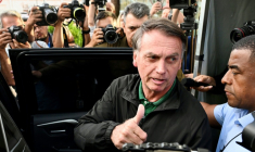 L'ancien président brésilien Jair Bolsonaro fait un signe de pouce levé en quittant le siège de la police fédérale après avoir été interrogé dans le cadre d'une enquête visant l'un de ses fils, à Brasilia, le 5 juin 2025 ( AFP / EVARISTO SA                   )