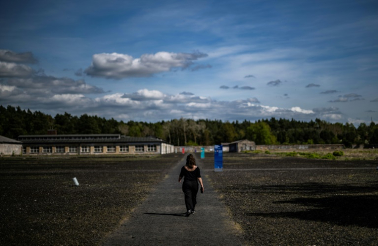 Une femme marche dans le camp de concentration de Ravensbrück, au nord de Berlin, le 25 avril 2025 ( AFP / John MACDOUGALL )