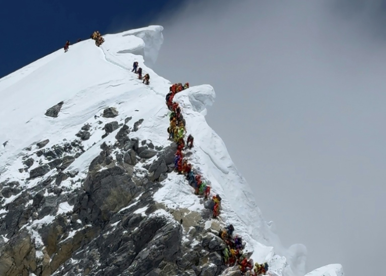 Des alpinistes gravissent une pente lors de leur ascension du ressaut Hillary vers le sommet de l'Everest, le 20 mai 2026 au Népal ( AFP / Furte Sherpa )