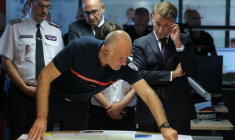 Le directeur du Sdis de Gironde, Marc Vermeulen (C), fait un brief sur l'incendie en présence d'Emmanuel Macron le 27 juillet 2026 à Bordeaux ( POOL / Kenzo TRIBOUILLARD )