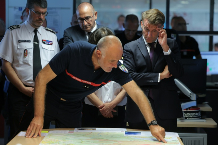 Le directeur du Sdis de Gironde, Marc Vermeulen (C), fait un brief sur l'incendie en présence d'Emmanuel Macron le 27 juillet 2026 à Bordeaux ( POOL / Kenzo TRIBOUILLARD )