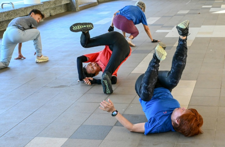 Des personnes âgées s'échauffent avant une séance d'entraînement de parkour à Singapour, le 17 mars 2026 ( AFP / Roslan RAHMAN )