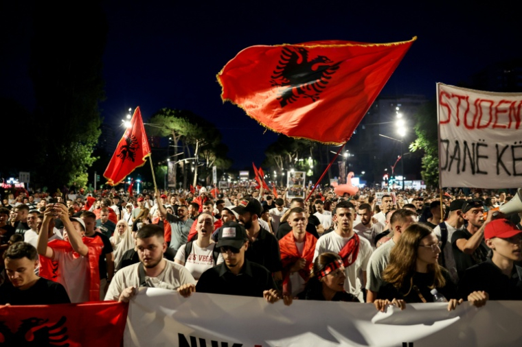 Des manifestants albanais, brandissant le drapeau national, protestent contre un projet touristique lié à la famille Trump, à Tirana, le 11 juin 2026 ( AFP / Adnan Beci )