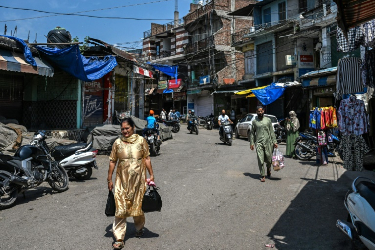Des habitants sur le marché de Poonch, en Inde, où les armes se sont tues après quatre jours d'affrontements avec le Pakistan, le 11 mai 2025 ( AFP / Punit PARANJPE )