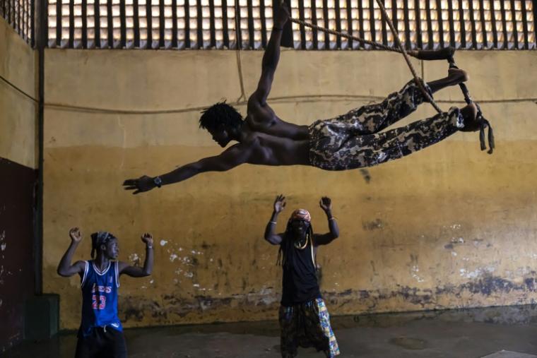 Le contorsionniste Mohamed Fofana s'entraîne au trapèze au centre d'art acrobatique Fodéba Keïta, le 6 septembre 2025 à Conakry, en Guinée ( AFP / PATRICK MEINHARDT )