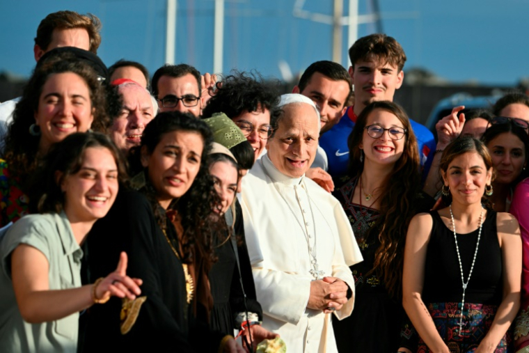 Pope Leo XIV poses with the crew of the Peace training ship "MED 25 - Bel Espoir", in the port of Ostia near Rome on October 17, 2025. The Mar Yam association, the AJD - Bel Espoir association and the diocese of Marseille organised the MED 25 - Bel Espoir odyssey for Peace from March to October 2025, 8 months of navigation as many thematic conferences and festivals with 30 stopovers on the 5 shores of the Mediterranean, with 200 young people on board (in groups of 25), of all faiths and religions. ( AFP / Alberto PIZZOLI )