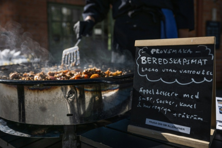 Préparation d'un plat au café Hitom à Hägersten, au sud de Stockholm, lors d'une initiative visant à sensibiliser aux repas qui peuvent être préparés dans des conditions d'état d'urgence, le 23 septembre 2025 en Suède ( AFP / Jonathan NACKSTRAND )