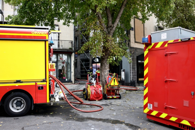 Des pompiers à proximité d'un immeuble ravagé par un incendie dans lequel trois corps ont été retrouvés, le 31 octobre 2026 à Clermont-Ferrand ( AFP / Alex MARTIN )