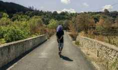 Un raver sur un pont près du site où se déroule la rave party de Fontjoncouse, dans l'Aude, le 30 août 2025 ( AFP / Idriss Bigou-Gilles )