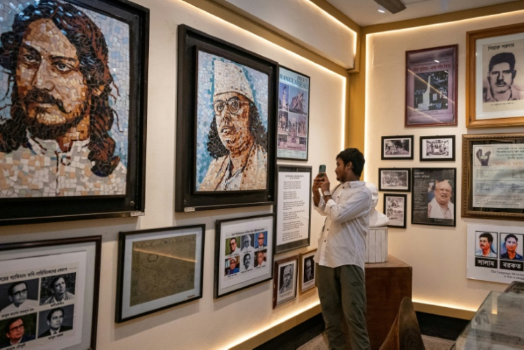 Un visiteur devant des photos exposées au musée de la maison des étudiants de l'Université de Dacca, le 17 septembre 2026 au Bangladesh ( AFP / Salahuddin AHMED )