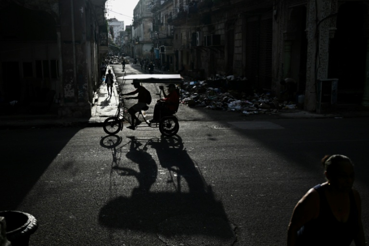 Un vélo-taxi circule dans une rue de La Havane pendant une vaste panne de courant, le 18 septembre 2026 ( AFP / YAMIL LAGE )