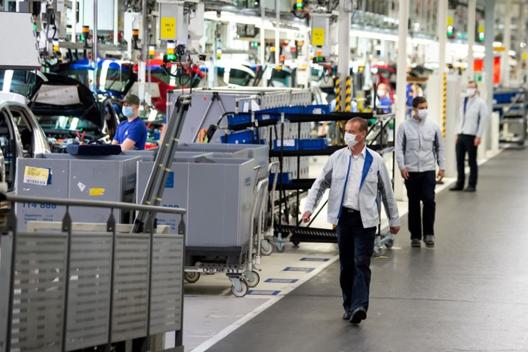 Des membres du personnel portent des masques de protection dans une usine de Volkswagen à Wolfsburg, en Allemagne