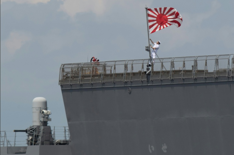 Un marin hisse le pavillon des Forces maritimes d'autodéfense japonaises à bord du JS Ise, un destroyer porte-hélicoptères de classe Hyuga, lors de son arrivée au port international de Manille, le 21 juin 2025 aux Philippines ( AFP / Ted ALJIBE )