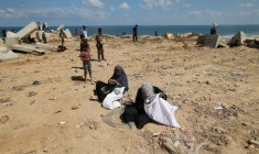 Des Palestiniennes fouillent le sol à la recherche de restes de colis de vivres à Nousseirat, dans le centre de la bande de Gaza, le 5 août 2025 ( AFP / Eyad BABA )