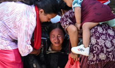 Une femme s'effondre tandis qu’elle attend l’arrivée de ses proches dans un camp militaire après avoir été secourue des zones touchées par des crues subites, dans la ville de Battar Bazar, dans le district de Nuwakot au Népal, le 27 août 2026 ( AFP / Prakash MATHEMA )