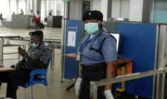 Des agents de sécurité aéroportuaire, portant des masques et des gants, sont en service à l'aéroport international Murtala Muhammed de Lagos, le 11 août 2014 ( AFP / PIUS UTOMI EKPEI )
