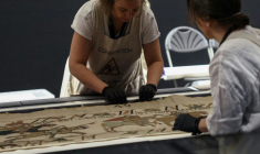 Des employées préparent la tapisserie de Bayeux présentée aux médias au British Museum, le 17 juillet 2026 à Londres ( AFP / Toby Shepheard )