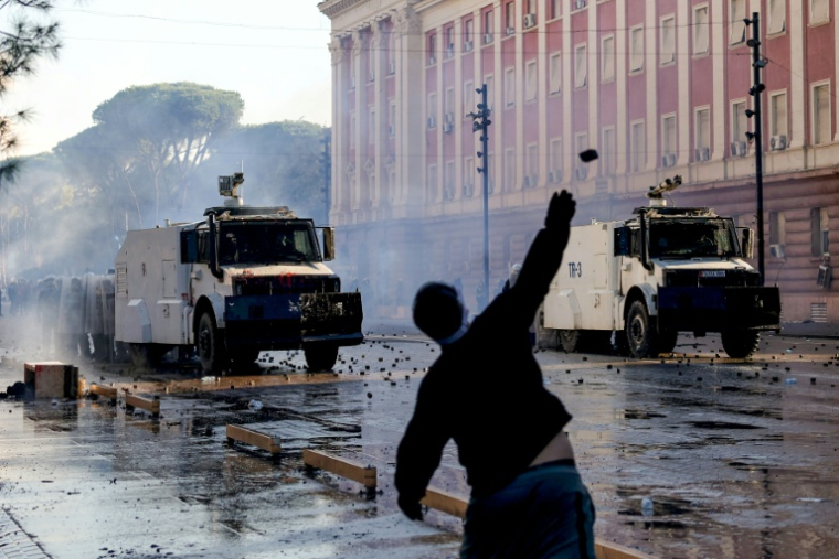 Un manifestant lance un pavé sur des policiers lors d’une manifestation antigouvernementale à Tirana, le 16 octobre 2026 en Albanie ( AFP / Adnan Beci )