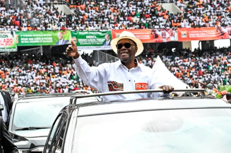 Le président ivoirien Alassane Ouattara salue la foule en arrivant au stade Ebimpé pour un meeting, le 22 juin 2025 à Abidjan (Côte d'Ivoire) ( AFP / Sia KAMBOU )
