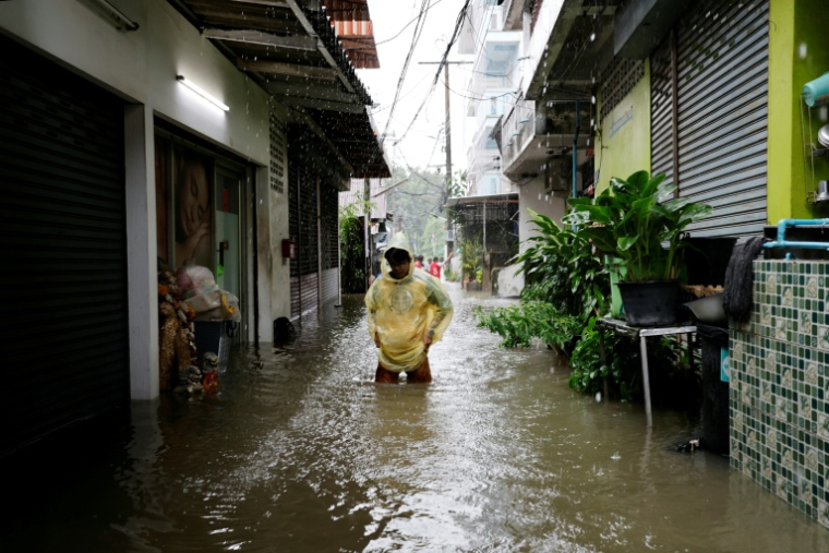 Une personne traverse les eaux de crue dans le district de Bang Bua à Bangkok, le 26 septembre 2026 ( AFP / WIKUS DE WET )