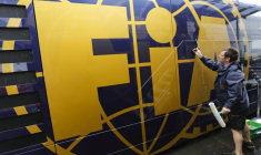 Un homme nettoie un camping-car de la Fédération internationale de l'automobile (FIA) dans le paddock du circuit du Nürburgring