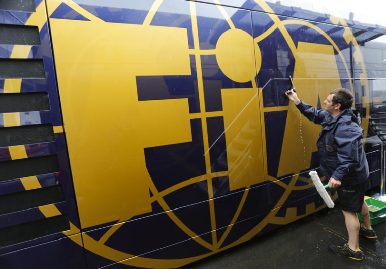 Un homme nettoie un camping-car de la Fédération internationale de l'automobile (FIA) dans le paddock du circuit du Nürburgring