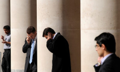 Des employés de la ville passent des appels téléphoniques devant la Bourse de Londres, sur Paternoster Square, dans la City de Londres