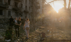 Des habitants se tiennent près d'un immeuble résidentiel endommagé dans des frappes russes sur Kiev, le 2 juillet 2026 ( AFP / Roman PILIPEY )