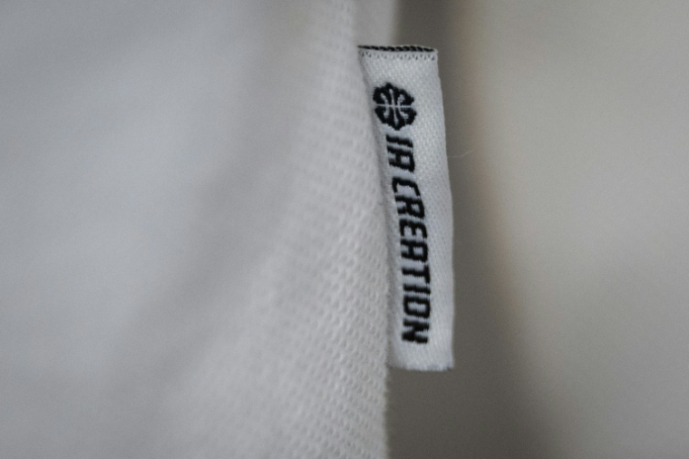 Une étiquette "IA creation" sur un polo conçu par IA dans les locaux de la startup Imki à Schiltigheim, près de Strasbourg, le 26 février 2025 ( AFP / SEBASTIEN BOZON )