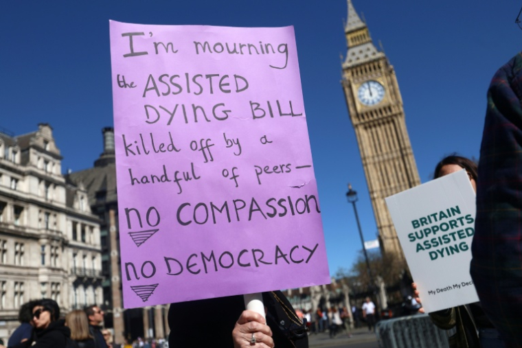 Des militants en faveur d'une modification de la loi sur l'aide médicale à mourir, rassemblés devant le palais de Westminster,le 24 avril 2026 à Londres ( AFP / Toby Shepheard )